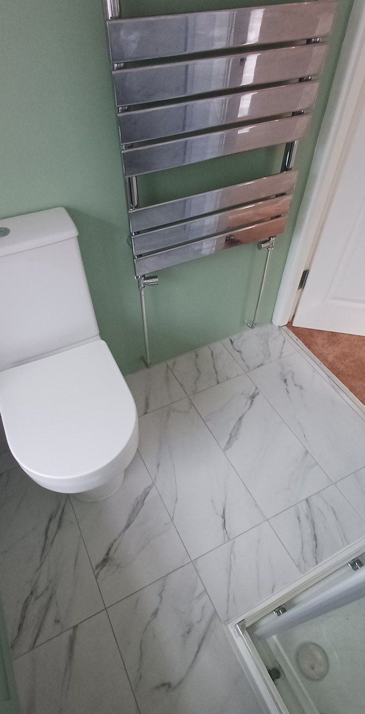 The same bathroom, WC and towel rail